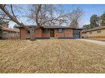 Charming brick home with a well-kept lawn and attached garage providing curb appeal at 725 S Harrison St, Denver, CO 80209