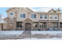 Inviting townhome exterior featuring stone accents, covered entryway, and well-maintained landscaping in a peaceful community at 10050 E Gunnison Pl # 805, Aurora, CO 80247