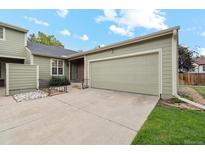 Charming exterior features a 2-car garage, lovely green paint, and a quaint front yard at 14333 E Warren Pl, Aurora, CO 80014