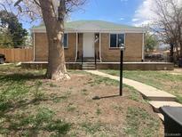 Charming brick home featuring a well-manicured lawn, inviting porch, and mature tree at 1326 S Canosa Ct, Denver, CO 80219