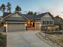 Inviting exterior view showcasing a two-car garage, stylish stonework, and well-manicured landscaping at 1775 Catnap Ln, Monument, CO 80132
