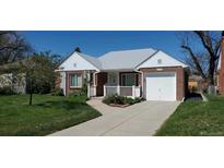 Charming red brick house with a well-manicured lawn and welcoming front porch at 5703 Ammons St, Arvada, CO 80002