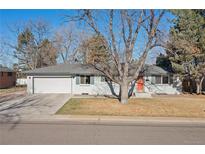 Charming single-story home featuring an attached garage, a well-maintained lawn and mature trees at 6537 S Lee Ct, Centennial, CO 80121