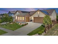 Inviting two-story home showcasing a well-manicured lawn, stone accents, and a two-car garage at 8142 S Langdale Way, Aurora, CO 80016