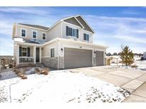 Two-story home with gray siding, a two-car garage, a covered front porch, and a well-maintained lawn at 5210 Gray Wolf Ln, Castle Rock, CO 80104