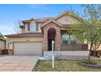 Inviting two-story home with a covered porch, neat landscaping, and a classic facade at 10288 Salida St, Commerce City, CO 80022