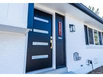 Modern black front door with glass accents on a charming white brick home at 4328 S Carr Ct, Littleton, CO 80123