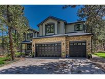 Inviting two-story home with a stone facade and attached three-car garage at 1410 Old Sequoia Ct, Franktown, CO 80116