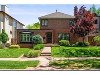Charming two-story brick home with a well-manicured lawn and beautiful landscaping at 720 S Clayton St, Denver, CO 80209