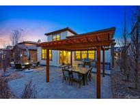 Backyard patio featuring a stone paver design, pergola, and outdoor seating at twilight at 15275 W La Salle Ave, Lakewood, CO 80228