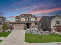 Charming two-story home featuring a stone facade, covered porch, and well-manicured front yard at 23879 E Narrowleaf Pl, Aurora, CO 80016