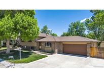 Charming two-story home with brick accents, mature trees, and a spacious driveway at 8272 Ammons Cir, Arvada, CO 80005