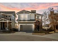 Charming two-story home featuring a modern garage door and a well-maintained lawn at sunset at 10627 Rutledge St, Parker, CO 80134