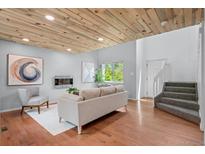 Bright living room featuring a wood ceiling, hardwood floors, and modern fireplace at 13245 Shoshone St, Denver, CO 80234