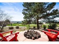 Enjoy the outdoors with a built-in firepit and scenic views of the golf course and surrounding hills at 6462 S Versailles Ct, Aurora, CO 80016