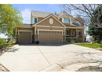 Beautiful two-story home featuring a three-car garage and stone accents, set in a well-manicured lawn at 6462 S Versailles Ct, Aurora, CO 80016