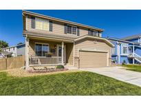 Inviting two-story home featuring a porch swing, well-kept lawn, and a two-car garage at 5090 Miriam Ln, Parker, CO 80134