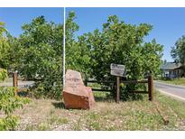 Louviers, Colorado entrance featuring a rock displaying its name with wooden split rail fence, and ample foliage at 7801 Valley View St, Louviers, CO 80131