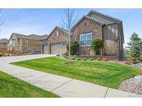 Charming front yard featuring lush green grass and decorative landscaping, enhancing the home's curb appeal at 7797 S Valleyhead Way, Aurora, CO 80016