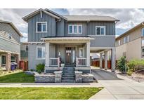 Charming two-story home with a welcoming front porch, manicured lawn and covered parking at 8444 E 55Th Pl, Denver, CO 80238