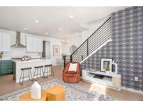 Open-concept living space featuring hardwood floors, designer wallpaper and contemporary furnishings at 5363 Quail St, Arvada, CO 80002