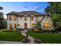 Elegant white brick home features manicured lawn, lush landscaping and timeless architectural design at 1027 S Fillmore Way, Denver, CO 80209