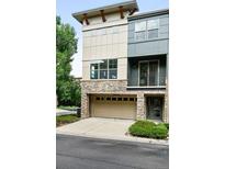 Modern townhome with stone accents, garage, balcony, and neutral two-tone paint at 13524 Via Varra, Broomfield, CO 80020