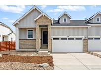 Charming townhome with a mix of stone and siding, complemented by a well-kept lawn and attached two-car garage at 3438 N Duquesne Way, Aurora, CO 80019