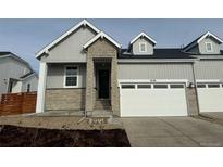 Charming home featuring light gray siding, stone accents, a one-car garage, and a well-maintained front yard at 3438 N Duquesne Way, Aurora, CO 80019