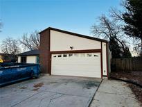 A two-car garage, trash dumpster and concrete driveway in front of the home at 4558 S Laredo St, Aurora, CO 80015