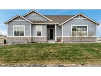 Charming single-story home with stone accents and manicured lawn at 16122 Emporia Way, Brighton, CO 80602