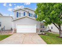 Charming two-story home with a well-maintained lawn, a two-car garage, and blue shutters at 9625 Bighorn Way, Littleton, CO 80125