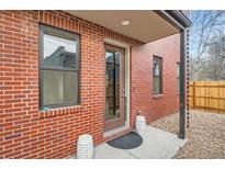 Charming brick home featuring a covered front entrance and a small, decorative front patio at 3643 Zuni St, Denver, CO 80211