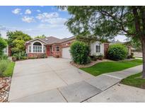 Charming single-story home with brick facade, manicured lawn, and large concrete driveway leading to a two-car garage at 3413 Boxelder Dr, Longmont, CO 80503