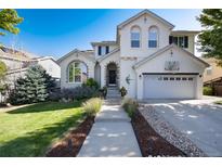 Charming two-story home with a well-manicured lawn, lovely landscaping, and a basketball hoop over the garage at 2880 Breezy Ln, Castle Rock, CO 80109