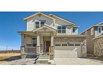 Charming two-story home features stone accents, a two-car garage, and a welcoming front porch, great curb appeal at 720 N Deer Park St, Watkins, CO 80137