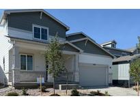 Charming two-story home featuring a covered porch, stone accents, and an attached garage at 1448 Orchard St, Brighton, CO 80601