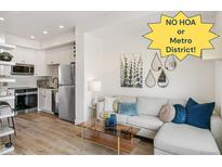 Bright living room featuring an open floor plan, white cabinets, stainless appliances, and modern decor at 5367 W 14Th Ave, Lakewood, CO 80214