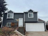 Gray two-story house with white garage door and landscaping at 6431 W 116Th Ave, Westminster, CO 80020