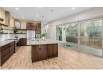 Modern kitchen featuring stainless steel appliances, granite counters, and an island with pendant lighting at 1848 W 68Th Ave, Denver, CO 80221