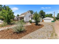 House exterior with gravel driveway and landscaping at 1111 E Dartmouth Ave, Englewood, CO 80113