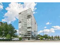 Modern high-rise building with glass facade against a backdrop of a partly cloudy blue sky at 3100 E Cherry Creek South Dr # 303, Denver, CO 80209