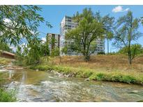 Scenic view of the building exterior near a flowing river and lush greenery at 3100 E Cherry Creek South Dr # 303, Denver, CO 80209