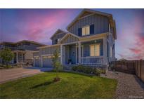 Charming two-story home with a well-manicured lawn and inviting front porch, showcasing its curb appeal at twilight at 10 N Quantock St, Aurora, CO 80018
