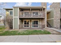 Attractive two-story condo features dual patios and a stylish stone chimney against a blue sky at 3400 S Eagle St # 104, Aurora, CO 80014