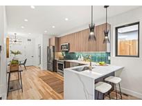 Bright kitchen featuring wood cabinets, stainless steel appliances, quartz countertop island, and modern pendant lighting at 1719 Grove St, Denver, CO 80204