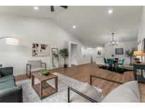 Bright living room with vaulted ceilings, wood floors, modern furnishings, and abundant natural light at 4043 E Geddes Cir, Centennial, CO 80122