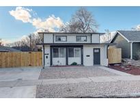 Charming two-story home featuring a modern facade, gravel yard, and a secure wooden fence at 4835 Grove St, Denver, CO 80221