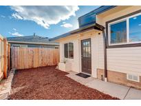 Charming front entrance with modern door, clean landscaping, and fenced yard for privacy at 4835 Grove St, Denver, CO 80221