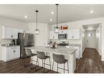 Bright kitchen features stainless appliances, granite counters, and a convenient island with barstool seating at 2326 Monte Vista St, Fort Lupton, CO 80621
